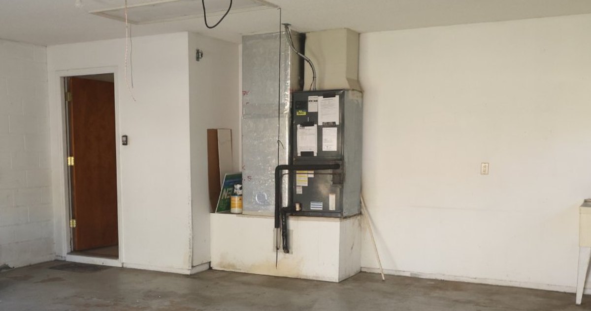 The old air handler in the garage of a Palm Coast flip before the change-out