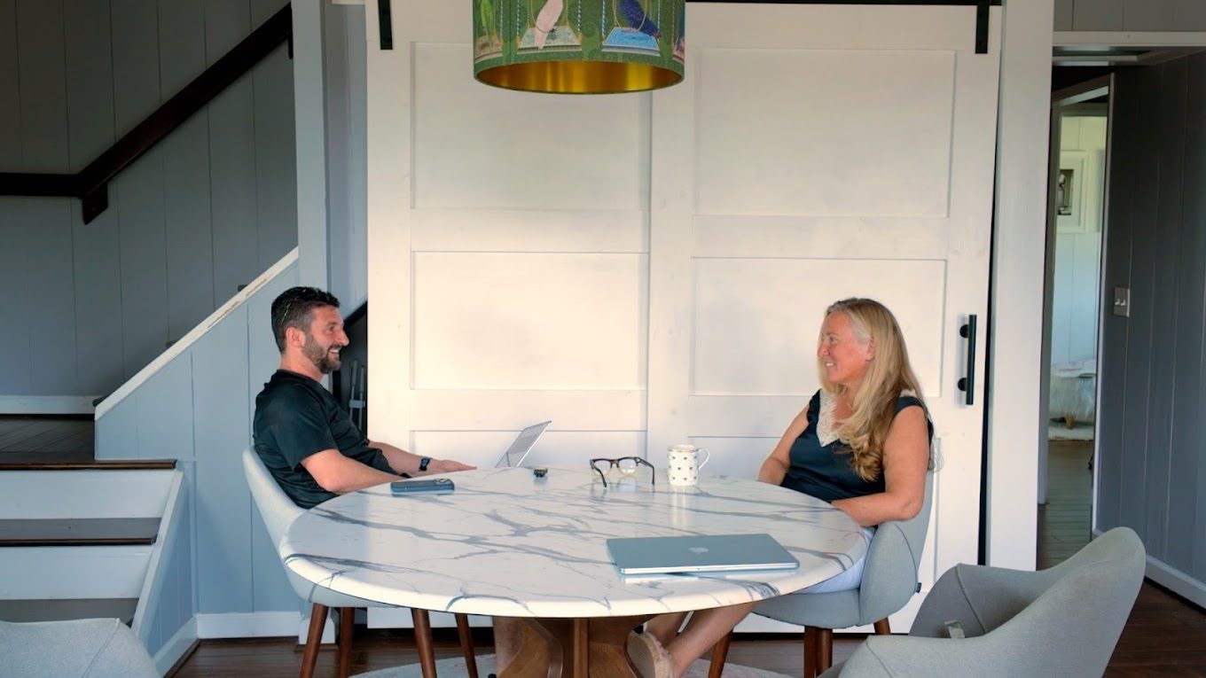 Robert T. Szigeti and Anne McNamara talking across her dining table