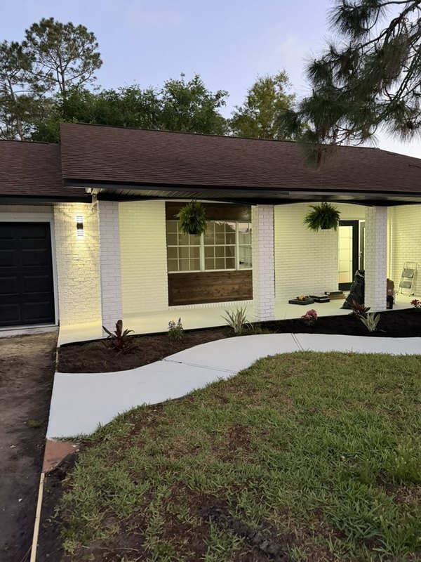 The same house painted white with black trim after the remodel