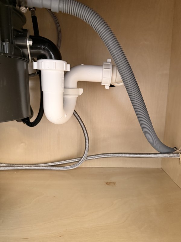 New drain and supply lines under a kitchen sink in a Palm Coast house
