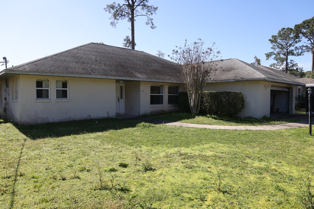 The Forest Hill flip in Palm Coast before the new roof, with its old stained gray shingle roof